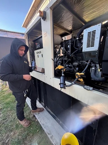 Technician servicing open generator panel on site