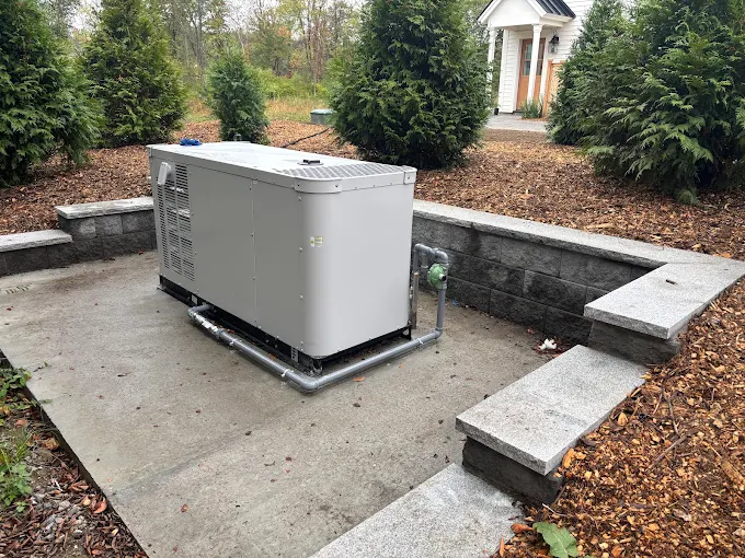 Generac standby unit on concrete pad, landscaped residential install